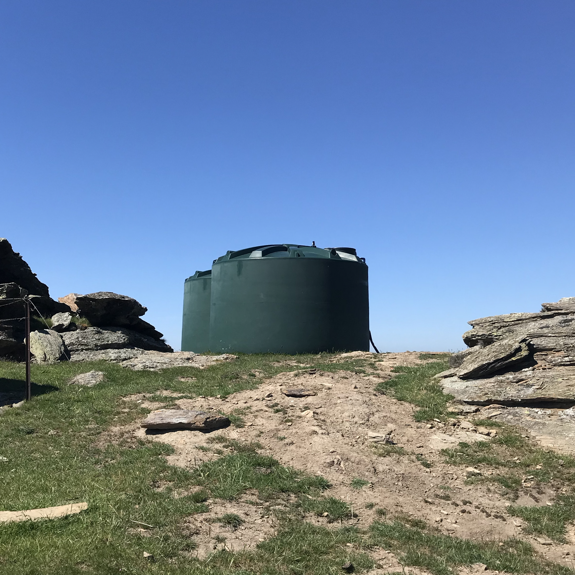 Farm water tanks on a rocky hill
